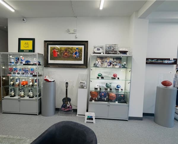 Sports memorabilia and a guitar displayed in glass cases and framed on the walls.